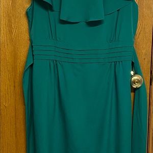Emeral green with bow tie strap to the back. Sleeveless and I I’ve the kneecap